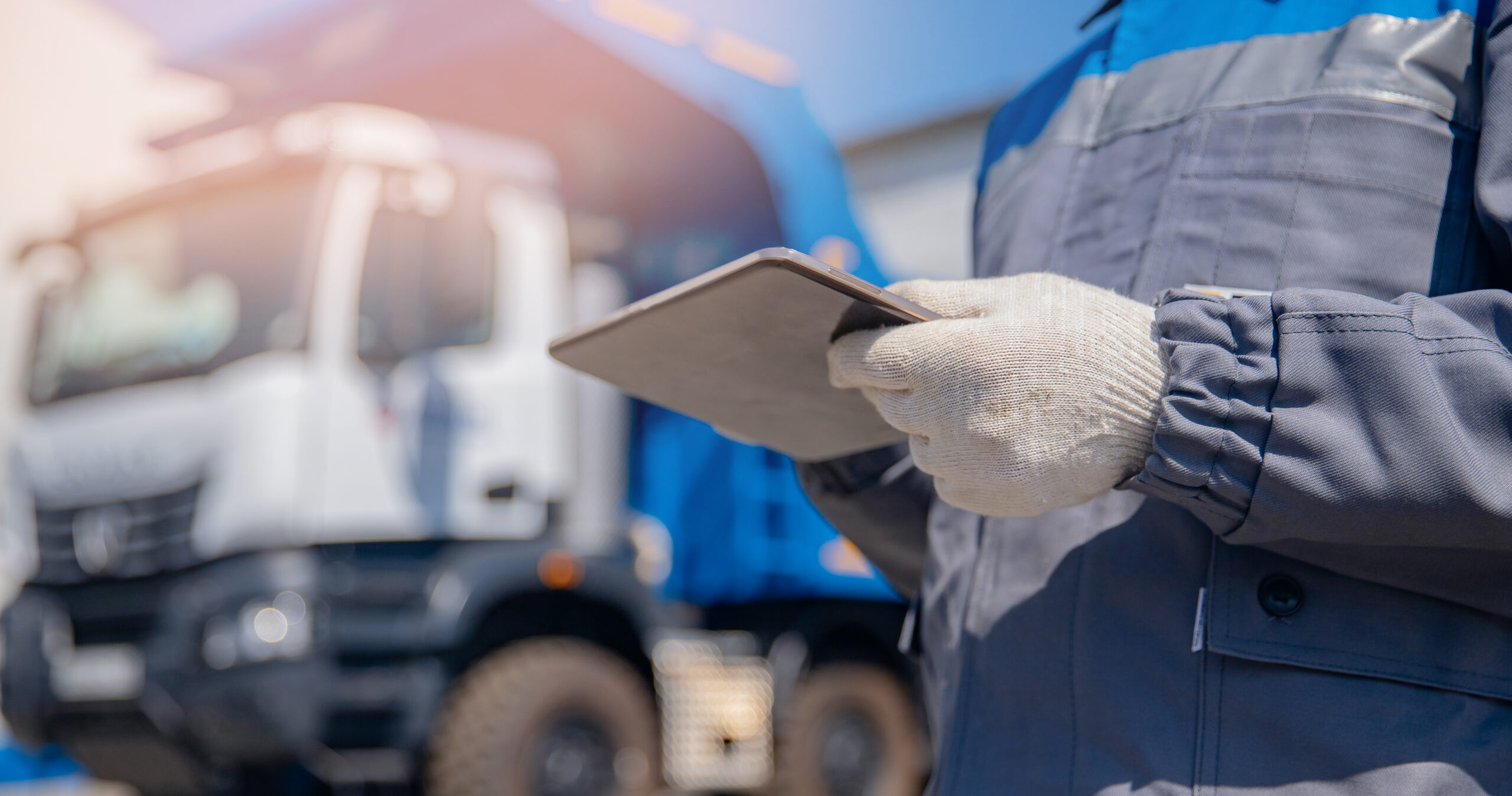 Concept banner automated logistics online internet. Dump truck driver man in uniform with tablet computer controls loading of cargo or coal.