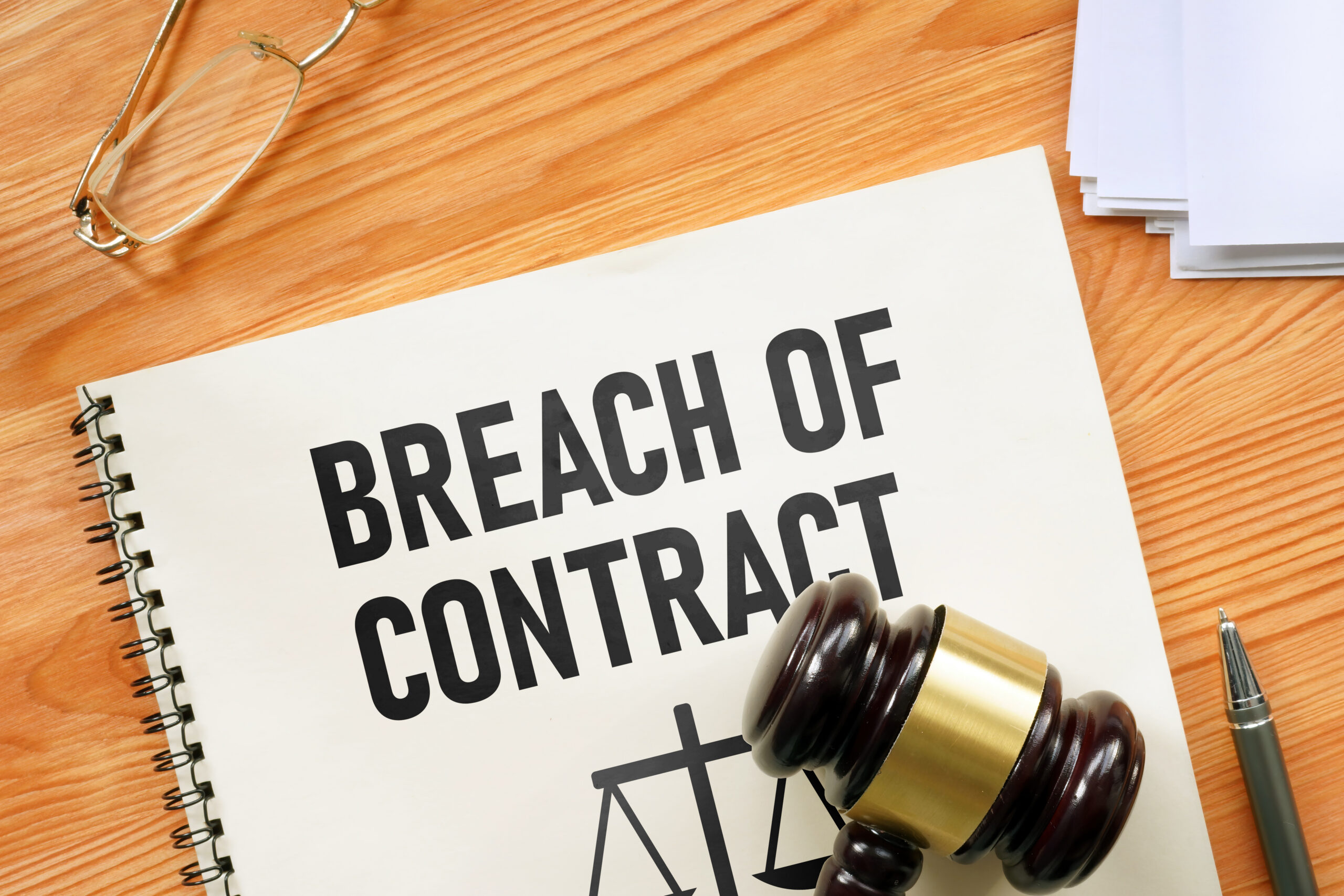 Breach of contract is shown using a text and photo of court gavel